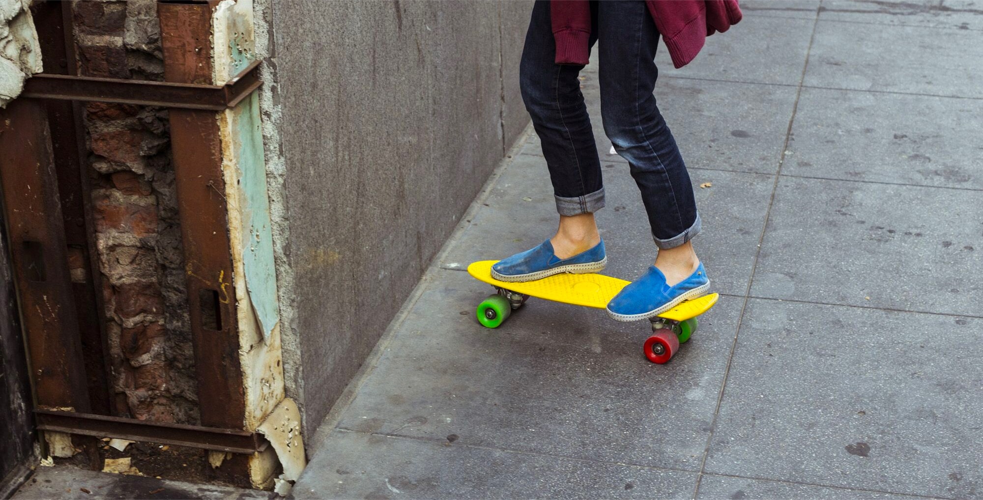 Close up of colorful skateboard with skateboarder on it in LA streets